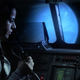 A solo astronaut speaks into a transmitter as a blue planet looms beyond her ship's front windows.
